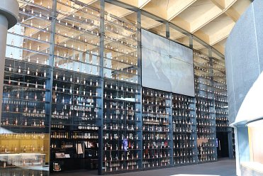 Full large glass wall with integrated whisky bottle display case